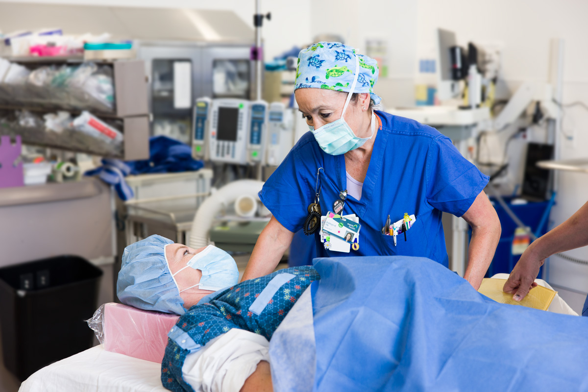 A pre-op hospital nurse talking with patient before a surgical procedure begins